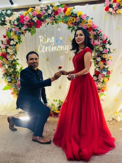 The classic proposal shot. The groom on one knee and the bride in a beautiful red ball gown create a timeless and romantic image for their ring ceremony.