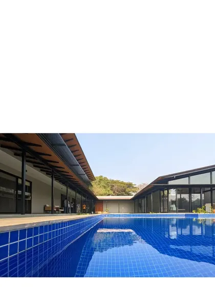 The two wings of Villa 15 face each other across a brilliant blue pool. The design uses a simple, one room thick plan and lofty roofs to create a comfortable and efficient holiday home in Alibaug.