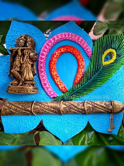 This handmade clay mural is inspired by the eternal love of Radha and Krishna. It combines textured clay work with vibrant painting and an antique-finish murti to create a spiritual centerpiece for your home.