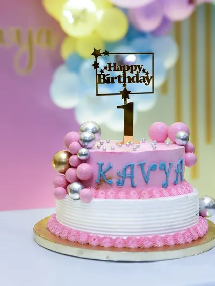 A pretty pink and blue cake for a first birthday. We make sure to get a clear, beautiful shot of the cake before it's enjoyed.