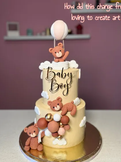 A sweet "Baby Boy" announcement cake. This two-tiered design features cute teddy bears, clouds, and a hot air balloon, creating a dreamy and gentle theme.