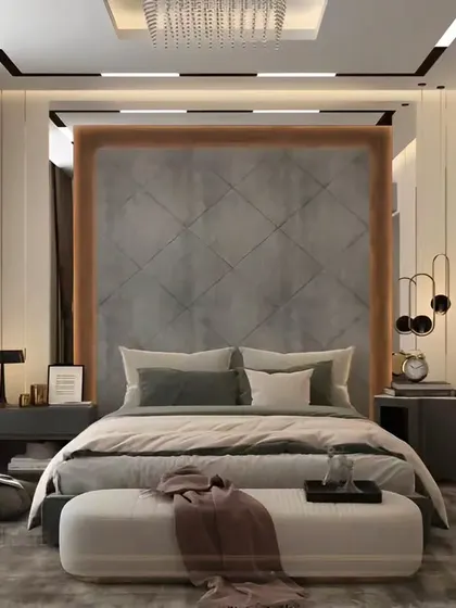 A luxurious master bedroom with a custom quilted headboard panel framed in wood. The design uses a mix of textures and sophisticated lighting to create a comfortable and elegant retreat.