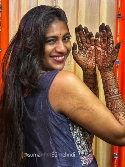 Another joyful pose showcasing the full bridal henna. You can see the detailed work on the palms, which includes traditional motifs that are central to a wedding celebration.