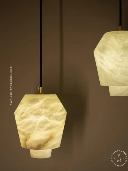 These geometric pendants are carved from a single piece of beige marble. Their unique, faceted shape and the soft glow from within make them a subtle yet elegant choice for modern kitchens or bedside lighting.