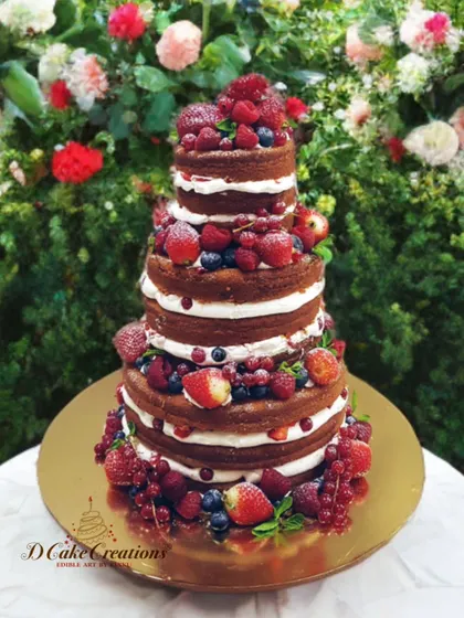 A celebration of fresh flavors. This multi-tiered "naked" cake is layered with fresh cream and generously decorated with a bounty of seasonal berries, including strawberries, blueberries, and raspberries.