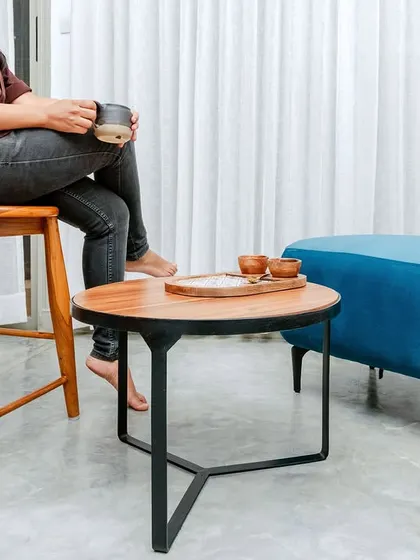 A detail shot of the custom furniture, including a solid wood stool and a bright blue pouf, which add functional and aesthetic value.