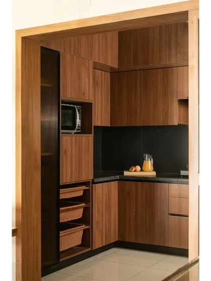 The 'Kayu' kitchen combines teak wood and black granite for a striking balance of warmth and sophistication. This modern yet timeless look proves that a minimalist kitchen can still be full of character and functionality.