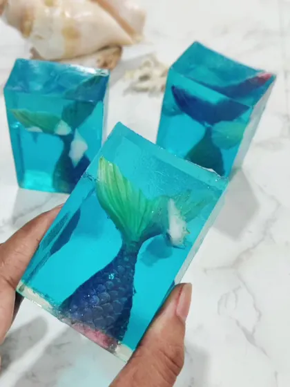 A vibrant mermaid tail soap, showing how color and embeds pop in a clear base.