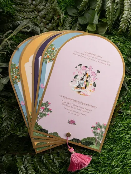 A fanned-out display of beautifully illustrated wedding inserts. The styling against a background of green leaves gives a fresh, organic feel to the stationery.