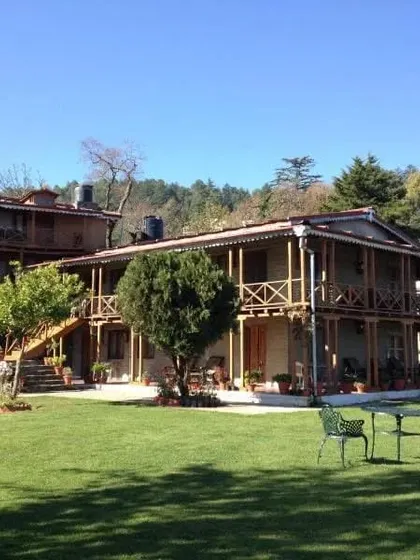 A full shot of the hotel building on a clear day, showcasing its rustic architectural style.