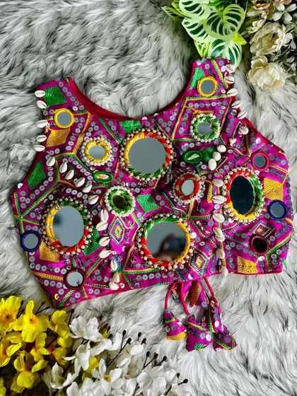 For those who love bold colors, this magenta blouse is covered in large and small mirrors and cowrie shells. It's a true showstopper.