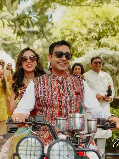 A close-up of the stylish couple on their ATV, both wearing sunglasses and ready to party.