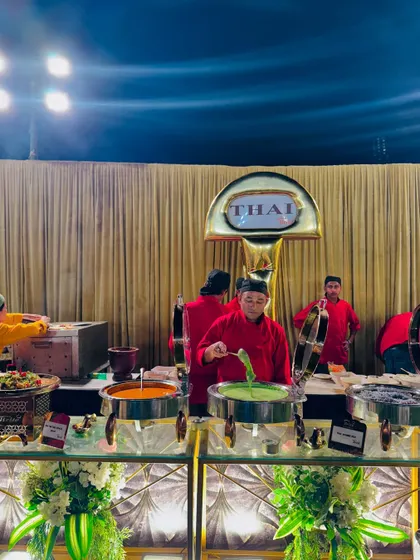 Chefs serving authentic green and red Thai curries at the live station.