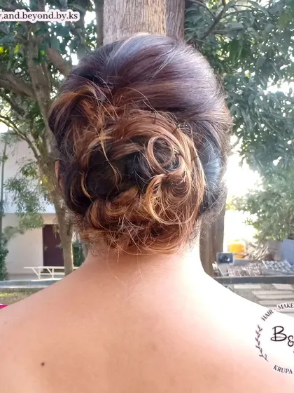 A close-up of the messy updo from image 14, highlighting the texture and interplay of colors from the client's hair. This style is particularly effective on hair with highlights or balayage.