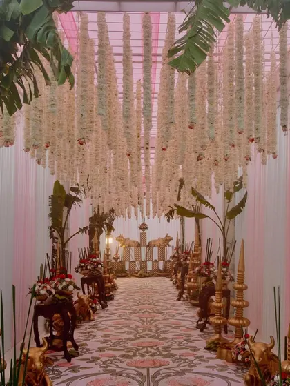 To honor tradition with elegance, I designed this South Indian wedding entrance. The aisle is lined with brass elements, banana leaf trees, and a ceiling of hanging tuberoses, creating a fragrant and culturally rich passage for the couple.