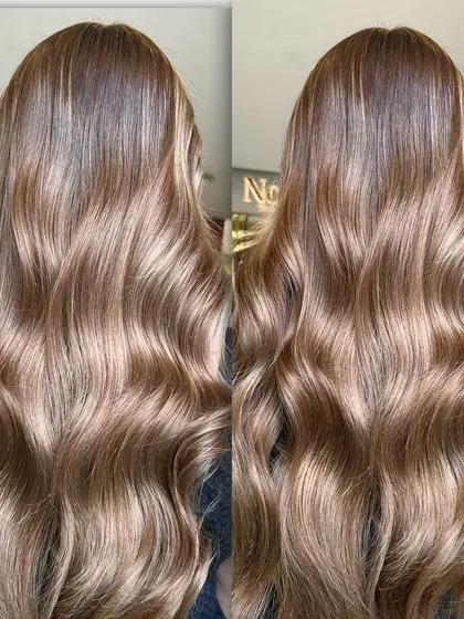 This side-by-side comparison shows the beautiful, cool-toned bronze lowlights in long hair. The color has a gingerbread biscuit feel, perfect for adding a touch of warmth to a cool palette.