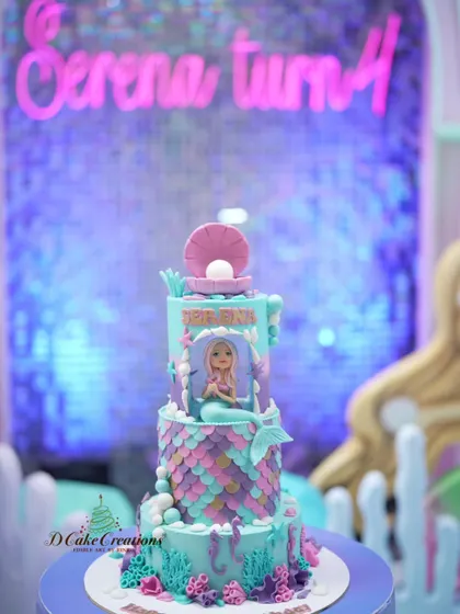 The mermaid cake in its party setting, perfectly matching the under-the-sea theme with its purple and blue lighting.