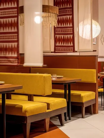 The seating at Tres Amigos is a mix of cozy booths and flexible tables. We used earthy yellow upholstery for the benches and custom-designed textile scrolls as partitions, creating a sense of intimacy while maintaining the restaurant's lively, communal feel.