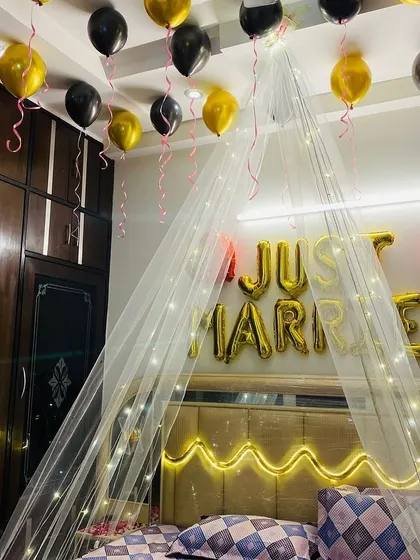 This photo shows the 'Just Married' foil balloons and the arrangement of black and gold balloons on the ceiling, creating a chic and celebratory look.