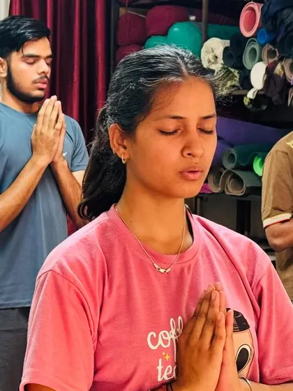 A close-up of students in prayer, their eyes closed in concentration. This moment of inner focus is a vital part of the practice.