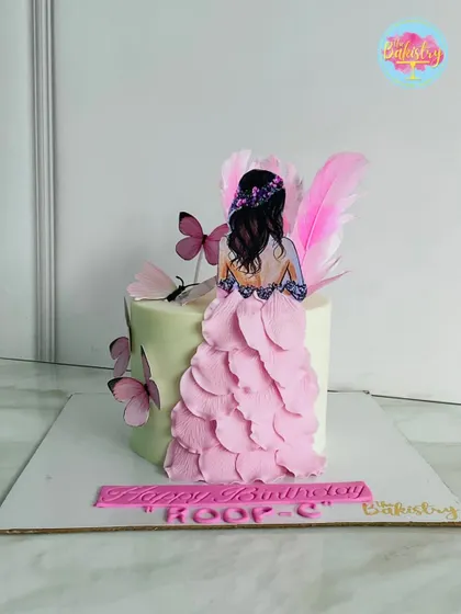 Here, elegance is redefined with this custom-themed masterpiece. The cake features a 3D effect with a beautiful figure and a flowing pink dress made of delicate petals.