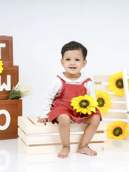 Holding a sunflower, this little one is the star of her second birthday session.