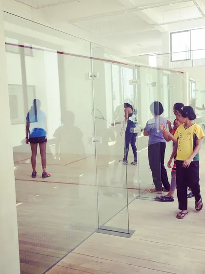 A view from outside the glass-back court, showing our coaches and players during a busy Monday session. We are always present and engaged, guiding our athletes through every drill.