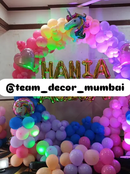 The unicorn theme decor illuminated with party lights, creating a dazzling effect for the celebration.