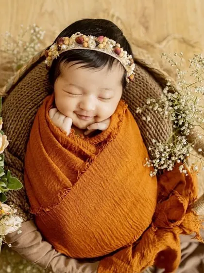 That sleepy newborn smile is just priceless. For my posed newborn sessions, I bring soft wraps, beautiful props, and a lot of patience to capture these peaceful, angelic portraits right in your home.