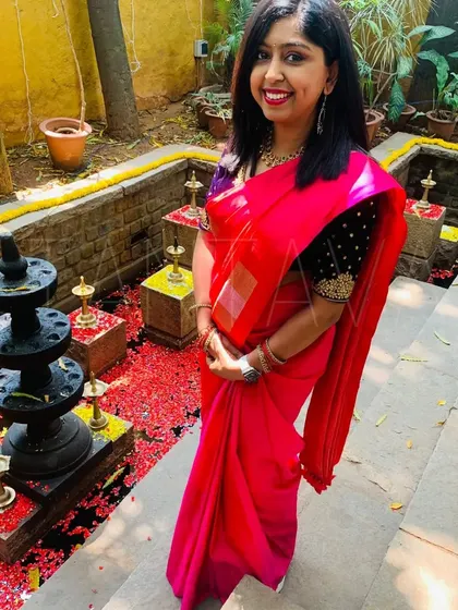 A gorgeous client from Australia wearing a custom hand-embroidered silk velvet blouse in a deep navy blue. The rich fabric and gold embroidery create a beautiful contrast with her pink saree.