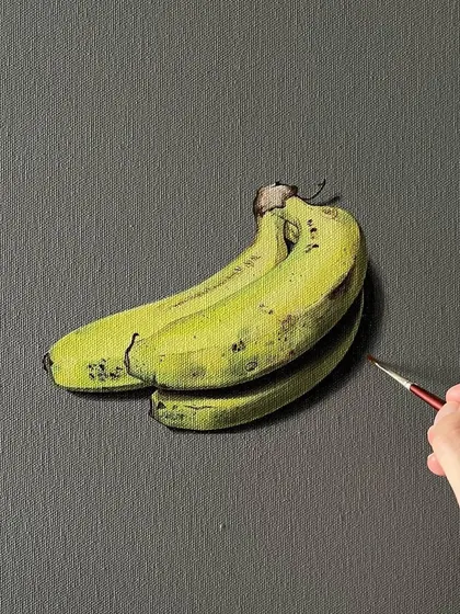 Another realistic painting of bananas in progress. Using a fine brush, I am adding the subtle dark spots and textures that make the fruit look lifelike.