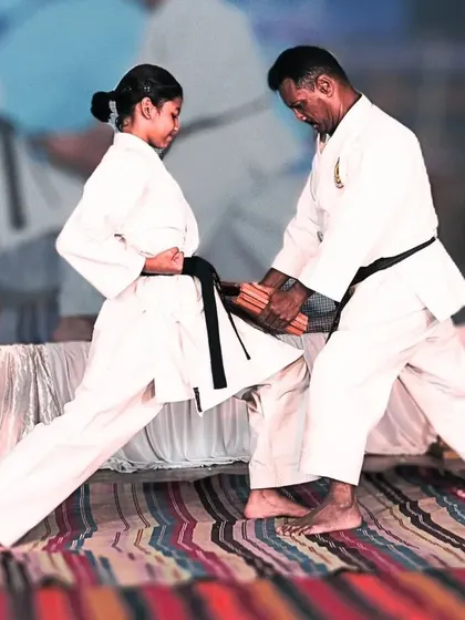 I provide direct guidance to all my students. Here, I am adjusting a female student's stance to ensure she develops maximum power and stability in her techniques.
