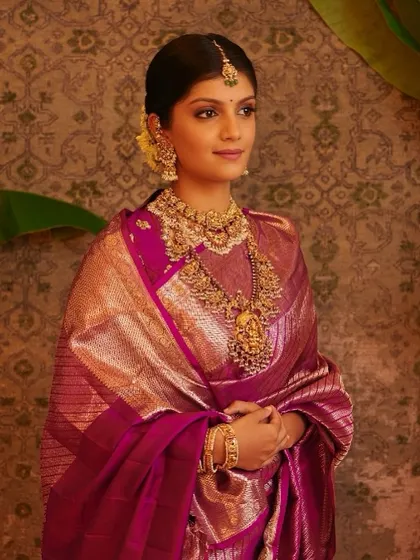 Draped in a rich purple Kanjeevaram, this bride's look is a beautiful blend of tradition and elegance. The makeup is soft and natural, with a jasmine-adorned bun completing the look.