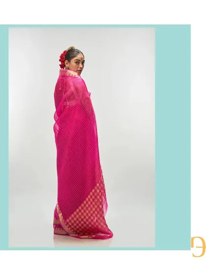 The back of the vivid cerise saree, capturing a moment of quiet elegance and showcasing the beautiful checkered pattern.