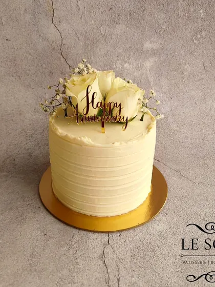 Sometimes, simple is the most beautiful. This half-kg Caramello Apple anniversary cake has a clean, white-on-white textured buttercream finish, topped with fresh white roses and baby's breath.