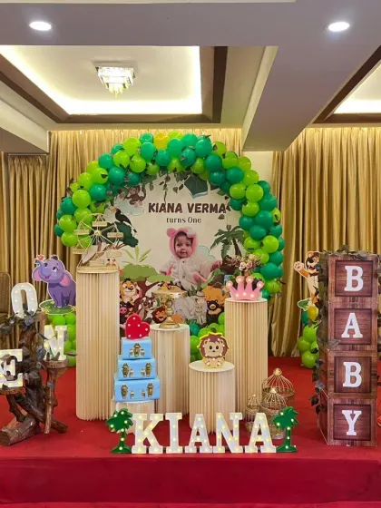 A jungle-themed first birthday for Kiana, featuring a variety of animal characters, wooden pedestals for the cake, and "BABY" blocks.