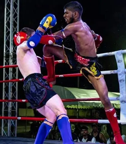 A fighter lands a sharp knee to the body of his opponent. This demonstrates the effectiveness of close range combat in Muay Thai.