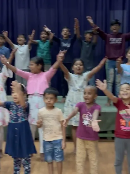 A duplicate of Image 13, showcasing the exuberant energy of our summer camp participants during a group activity. Their outstretched arms reflect the open and expressive atmosphere we cultivate.