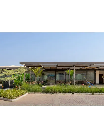 The exterior of Brigade Oasis showcases a long, low profile that sits gently in the landscape. The extensive use of glass and open pergolas makes the building feel light and transparent.