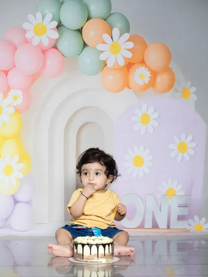 A cute shot of a baby enjoying his first taste of birthday cake.