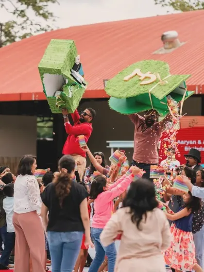 The piñata smash is always a highlight! Here, kids and adults gather to break open the giant Monopoly money bags, showering everyone with treats.