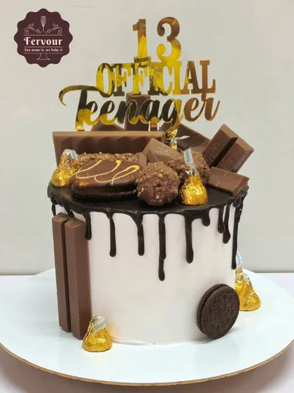 Another version of my popular chocolate overloaded cake, this one for a 13th birthday. It's a chocolate mousse cake with a white cream base, chocolate drip, and plenty of chocolate treats on top.