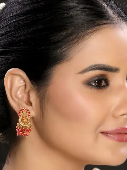 A close-up of another style of traditional jhumka with red beadwork, showing variations within a collection.