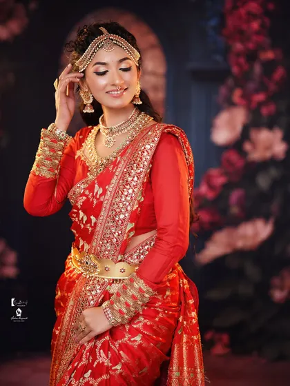 A classic bridal hairstyle with long, flowing waves and a traditional 'matha patti' headpiece.