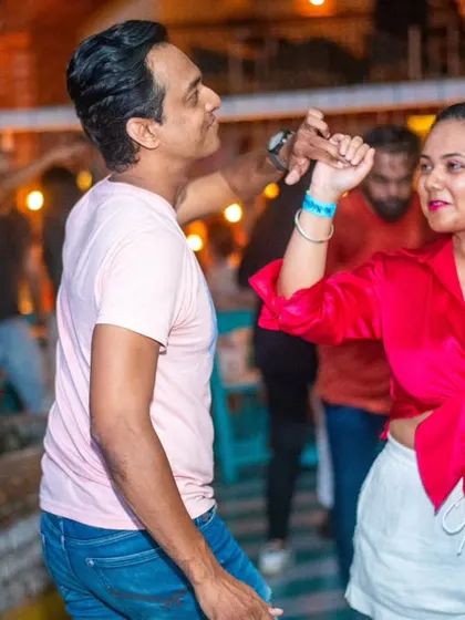A stylish couple enjoying the music. The bright pink top stands out on the dance floor.