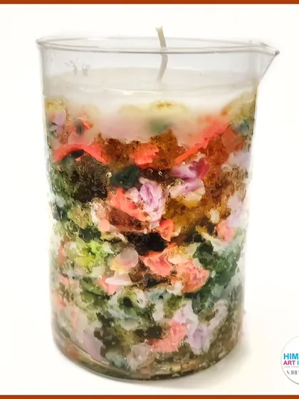 A creative candle made with embedded colorful elements. Our workshops encourage experimentation with different materials to create unique candle designs.