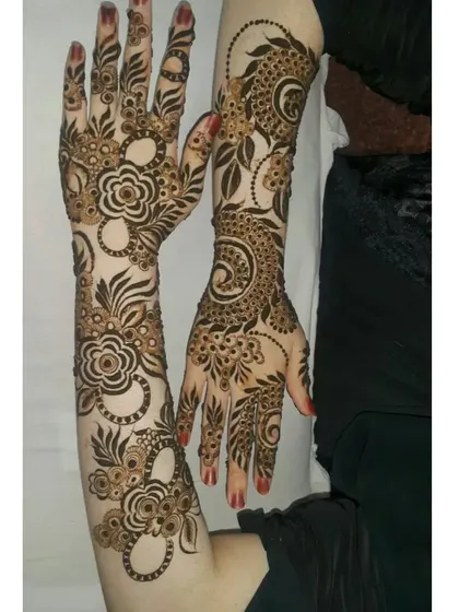 Two hands showcasing different but complementary Arabic-style floral and vine patterns.