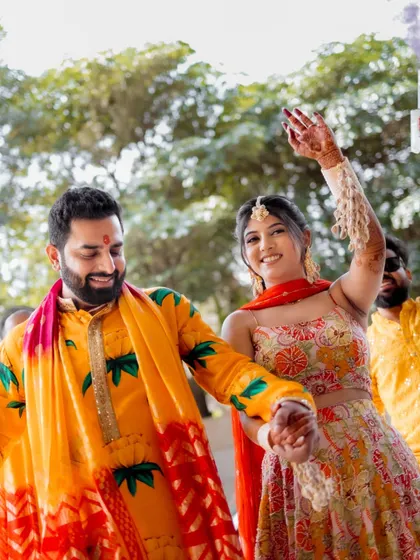 A candid shot of the couple dancing and enjoying their Haldi celebration.