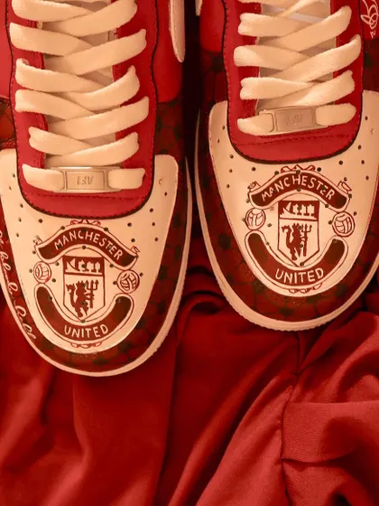 A top-down view of the Manchester United AF1s, showing the detailed club crest hand-painted on the toe box of each shoe.