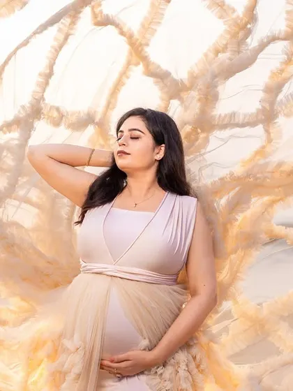 A moment of quiet contemplation, with the textured gown creating a beautiful and artistic backdrop for the mom-to-be.